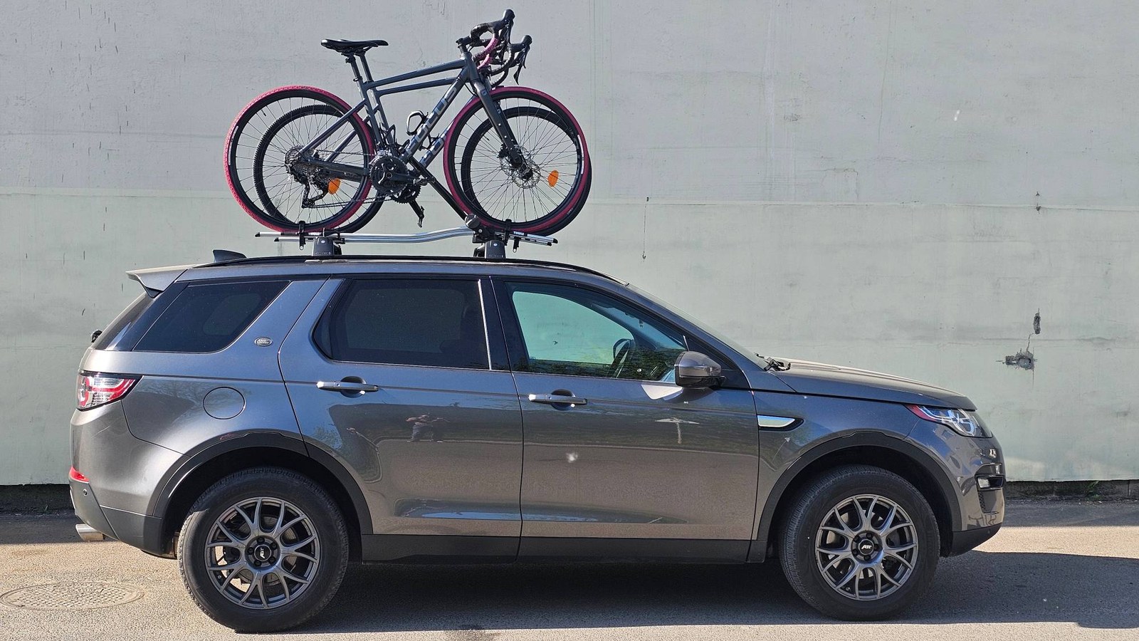 Сірий Land Rover Discovery Sport учасника клубу з велосипедами на даху